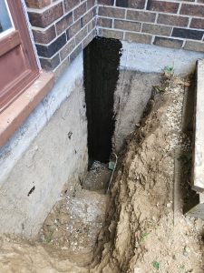 Excavated and waterproofed exterior foundation crack